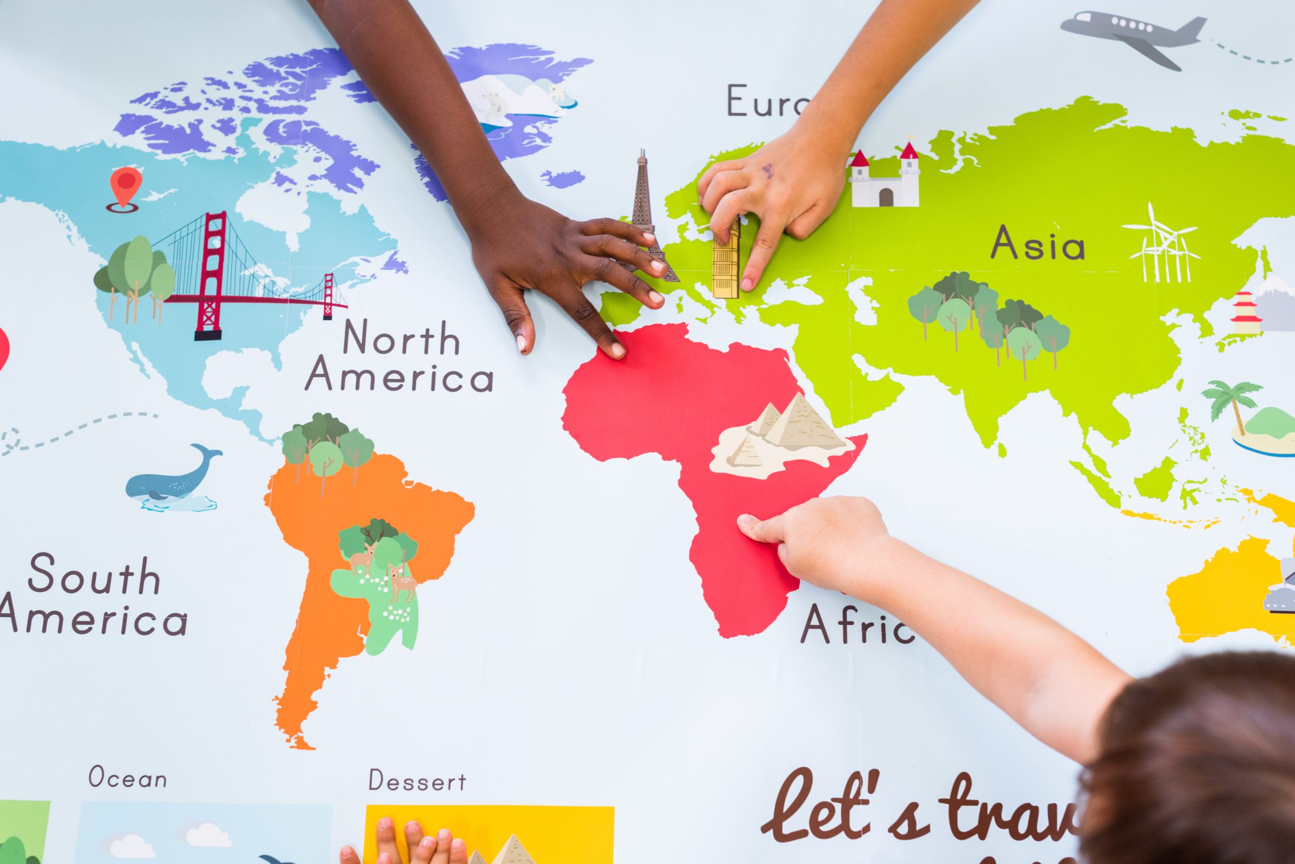 Children exploring a world map during an educational activity in Africa